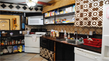 The women's kitchen features tiling and dark wood, adding to a feeling of home.